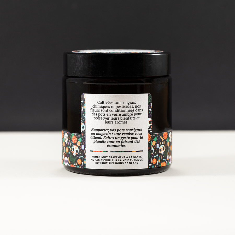 arrière du pot de fleurs de CBD M. Jones de chez Maison Sativa à Cherbourg. Il est écrit "cultivées sans engrais chimiques ni pesticides, nos fleurs de CBD sont conditionnées dans des pots en verre ambré pour préserver leurs bienfaits et leurs arômes. Rapportez vos pots consignés en magasin : une remise vous attend. Faites un geste pour la planète tout en faisant des économies."