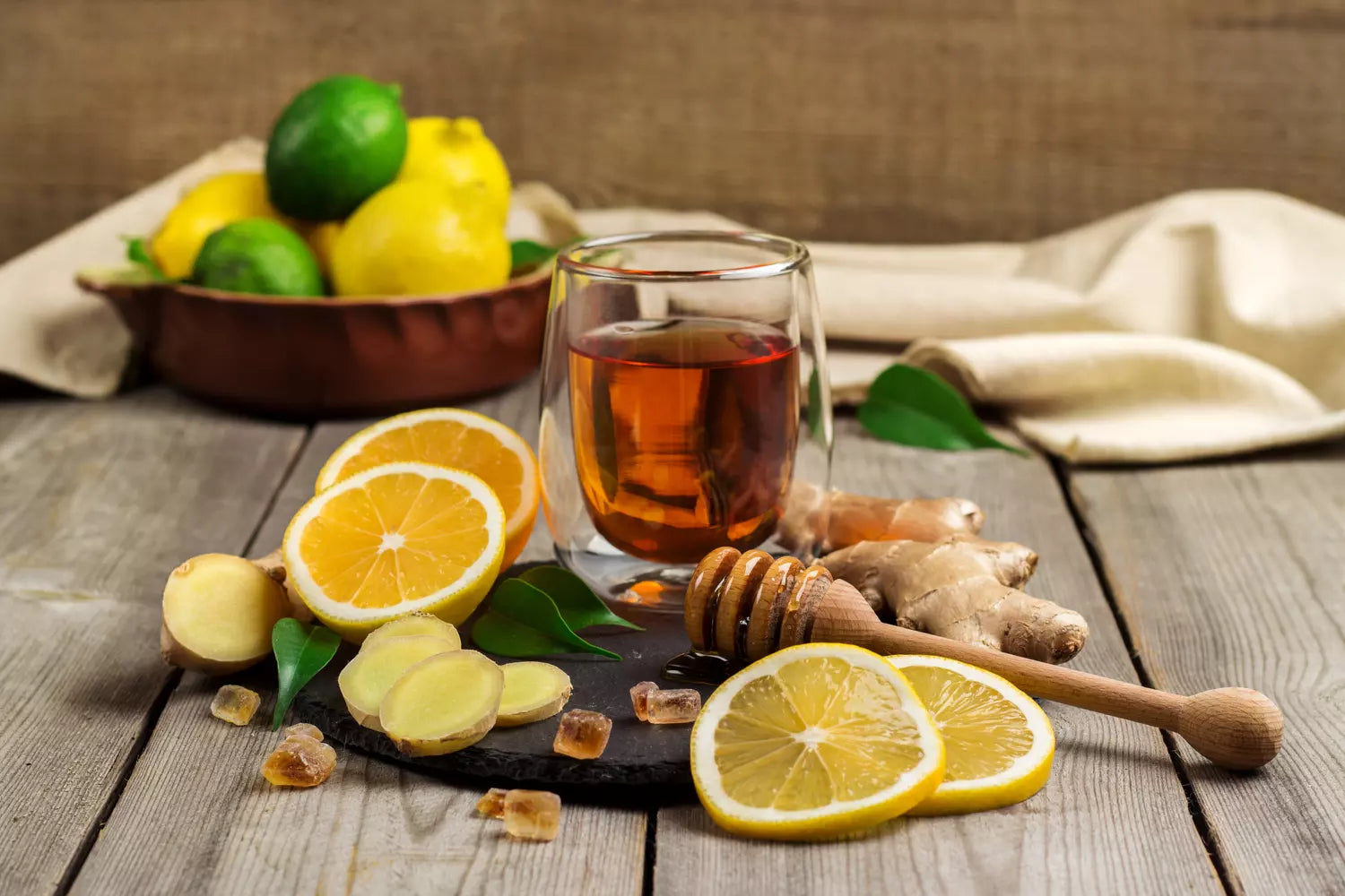 verre d'infusion détox entouré de citron et de gingembre