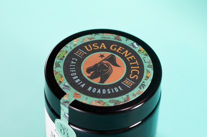 couvercle du pot de fleurs de CBD santa cruz, montrant le logo "USA GENETICS, California roadside"